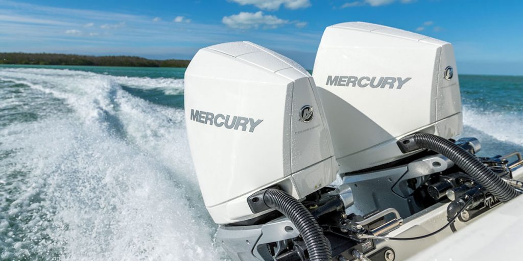 Two Mercury Engines on the back of a boat moving at speed in the water.